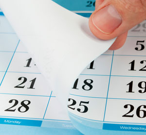 Image of hand turning the page of a calendar. Article covers why the stress of living through the pandemic is causing weak, peeling and brittle fingernails. Nailcarehq.com